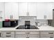 Modern kitchen with white cabinets, sleek countertops, and stainless-steel appliances at 2929 Siesta Dr, Venice, FL 34293