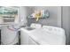 Laundry room features washer, dryer, shelving, and window for natural light at 2929 Siesta Dr, Venice, FL 34293