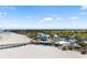 Aerial shot of a beach restaurant with palm trees, outdoor seating, and access to the sandy beach and beautiful waterfront at 2929 Siesta Dr, Venice, FL 34293