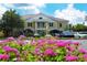 Beautiful community clubhouse with ample parking and lovely landscaping featuring vibrant pink flowers at 340 Osprey Point Dr, Osprey, FL 34229