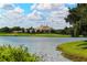 Scenic view of a grand estate situated on a picturesque lake and well-maintained golf course at 340 Osprey Point Dr, Osprey, FL 34229