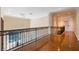 Elegant hallway featuring hardwood floors and ornate wrought iron railings overlooking the entry chandelier at 340 Osprey Point Dr, Osprey, FL 34229