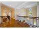 Upstairs hallway with hardwood floors and wrought iron railings overlooking a circular window at 340 Osprey Point Dr, Osprey, FL 34229