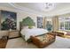 Serene main bedroom features large windows, upholstered headboard and sitting area at 340 Osprey Point Dr, Osprey, FL 34229