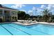 Relaxing community pool area with lounge chairs and well-manicured landscaping on a sunny day at 340 Osprey Point Dr, Osprey, FL 34229