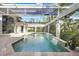 A gorgeous covered pool area features waterfall accents and views of the surrounding landscaping at 340 Osprey Point Dr, Osprey, FL 34229