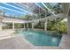 Outdoor pool area featuring a screened enclosure, integrated waterfall features, and lush landscaping at 340 Osprey Point Dr, Osprey, FL 34229