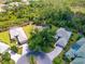 Aerial view showcasing the property's lush surroundings in a neighborhood with mature trees and circular driveways at 355 Melrose Ct, Venice, FL 34292