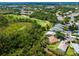 Aerial view of the home on a golf course, lush greenery, and lake views at 355 Melrose Ct, Venice, FL 34292