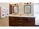 Bathroom features a dual sink vanity, elegant framed mirrors, decorative tile backsplash, and ample storage at 355 Melrose Ct, Venice, FL 34292