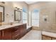 Bathroom features a dual sink vanity, elegant framed mirrors, a decorative tile backsplash, and a glass enclosed walk-in shower at 355 Melrose Ct, Venice, FL 34292