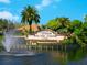 The Venice Golf and Country Club grand entrance with a fountain, lush landscaping, and clear blue skies at 355 Melrose Ct, Venice, FL 34292