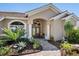 Inviting front entrance with a paver walkway and lush tropical landscaping at 355 Melrose Ct, Venice, FL 34292