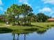 Golfers enjoy playing a game on the community golf course with a scenic pond at 355 Melrose Ct, Venice, FL 34292