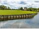 Beautiful view of the golf course with green fairway and water hazard, reflecting cloudy sky, offering a serene landscape at 355 Melrose Ct, Venice, FL 34292