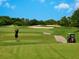 Personal tees off on the golf course with sand traps and green fairway at 355 Melrose Ct, Venice, FL 34292