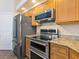 Modern kitchen featuring stainless steel appliances, granite countertops and wooden cabinets at 355 Melrose Ct, Venice, FL 34292