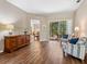 A brightly lit living room with hardwood floors, neutral walls, and views of the outside patio at 355 Melrose Ct, Venice, FL 34292