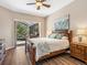 Bright primary suite features a ceiling fan, ensuite bath, and sliding glass doors to a screened patio and pool at 355 Melrose Ct, Venice, FL 34292