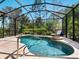 A beautiful screened-in pool and spa area with a lounge chair for relaxing by the water at 355 Melrose Ct, Venice, FL 34292