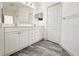 Bright bathroom featuring double sinks, white cabinetry, and modern gray tile flooring at 3706 Shimmering Oaks Dr, Parrish, FL 34219