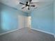 Airy blue bedroom with carpeted floors, ceiling fan, and a closet at 3706 Shimmering Oaks Dr, Parrish, FL 34219