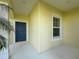 Welcoming entryway with blue front door, decorative window, and pale yellow siding at 3706 Shimmering Oaks Dr, Parrish, FL 34219
