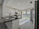 Bright, spacious kitchen featuring white cabinetry, stainless appliances, and backyard views at 3706 Shimmering Oaks Dr, Parrish, FL 34219