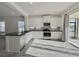 Bright kitchen features white cabinets, stainless steel appliances, tile floors and black countertops at 3706 Shimmering Oaks Dr, Parrish, FL 34219