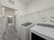 Convenient laundry room with appliances, shelving, and modern flooring at 3706 Shimmering Oaks Dr, Parrish, FL 34219