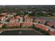 Aerial view of a community showcasing well-maintained homes, lush landscaping, and a beautiful pond with a fountain at 4236 Expedition Way # 106, Osprey, FL 34229