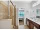 Primary bath featuring a glass enclosed shower, a double sink vanity, and access to the main bedroom at 4236 Expedition Way # 106, Osprey, FL 34229