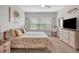 Bright bedroom with a floral patterned comforter, a ceiling fan, and a window with lots of natural light at 4236 Expedition Way # 106, Osprey, FL 34229