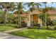Inviting exterior featuring lush landscaping, a manicured lawn, and a charming walkway at 4236 Expedition Way # 106, Osprey, FL 34229