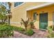Inviting entryway with brick path and green door and nice landscaping at 4236 Expedition Way # 106, Osprey, FL 34229