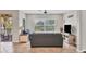 Comfortable living room featuring gray sofa, large window with blinds, and access to an outdoor balcony at 4236 Expedition Way # 106, Osprey, FL 34229