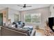 Comfortable living room features neutral tones, ceiling fan, and view of lush greenery at 4236 Expedition Way # 106, Osprey, FL 34229