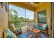 Serene screened-in patio with comfortable seating offering beautiful views of a lake and mature trees at 4236 Expedition Way # 106, Osprey, FL 34229