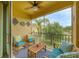 Relaxing screened-in patio with comfortable seating and a ceiling fan overlooking a pond and lush greenery at 4236 Expedition Way # 106, Osprey, FL 34229