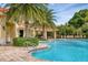 Community pool with nearby covered outdoor seating and tropical plants at 4236 Expedition Way # 106, Osprey, FL 34229