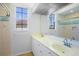 Bright bathroom with double sinks, a large mirror, and a tiled shower with decorative accents at 4713 Sweetmeadow Cir, Sarasota, FL 34238