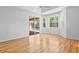 Light-filled living room with hardwood floors and multiple windows overlooking the backyard and pool area at 4713 Sweetmeadow Cir, Sarasota, FL 34238