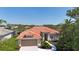 Stunning aerial view of home boasting red tile roof, lush greenery, and waterfront views, creating serene oasis at 4961 Sabal Lake Cir, Sarasota, FL 34238