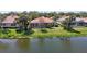 Home with large back yard, screened in patio, palm trees, and a lake view at 4961 Sabal Lake Cir, Sarasota, FL 34238