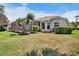 A well-maintained backyard with green grass, landscaping, and screened lanai at 4961 Sabal Lake Cir, Sarasota, FL 34238