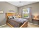 Bedroom with wooden bed frame, neutral walls, and view to the outside at 4961 Sabal Lake Cir, Sarasota, FL 34238