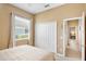 Well lit bedroom with a white quilt, closet, and view to the exterior at 4961 Sabal Lake Cir, Sarasota, FL 34238