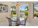 Cozy breakfast nook with a glass table, scenic views of the lake, and lush landscaping at 4961 Sabal Lake Cir, Sarasota, FL 34238