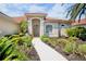 Charming home featuring a red tile roof and lovely landscaping that leads to the inviting front entrance at 4961 Sabal Lake Cir, Sarasota, FL 34238
