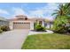Charming single-story home with a red tile roof, attached two-car garage and inviting, well-maintained lawn at 4961 Sabal Lake Cir, Sarasota, FL 34238